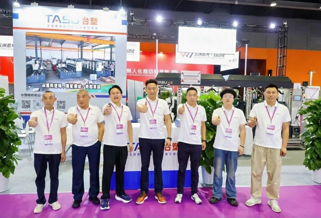 Il team TASU presso lo stand GISMA Guangzhou 2026 di fronte alle attrezzature per lo stampaggio a iniezione della gomma.